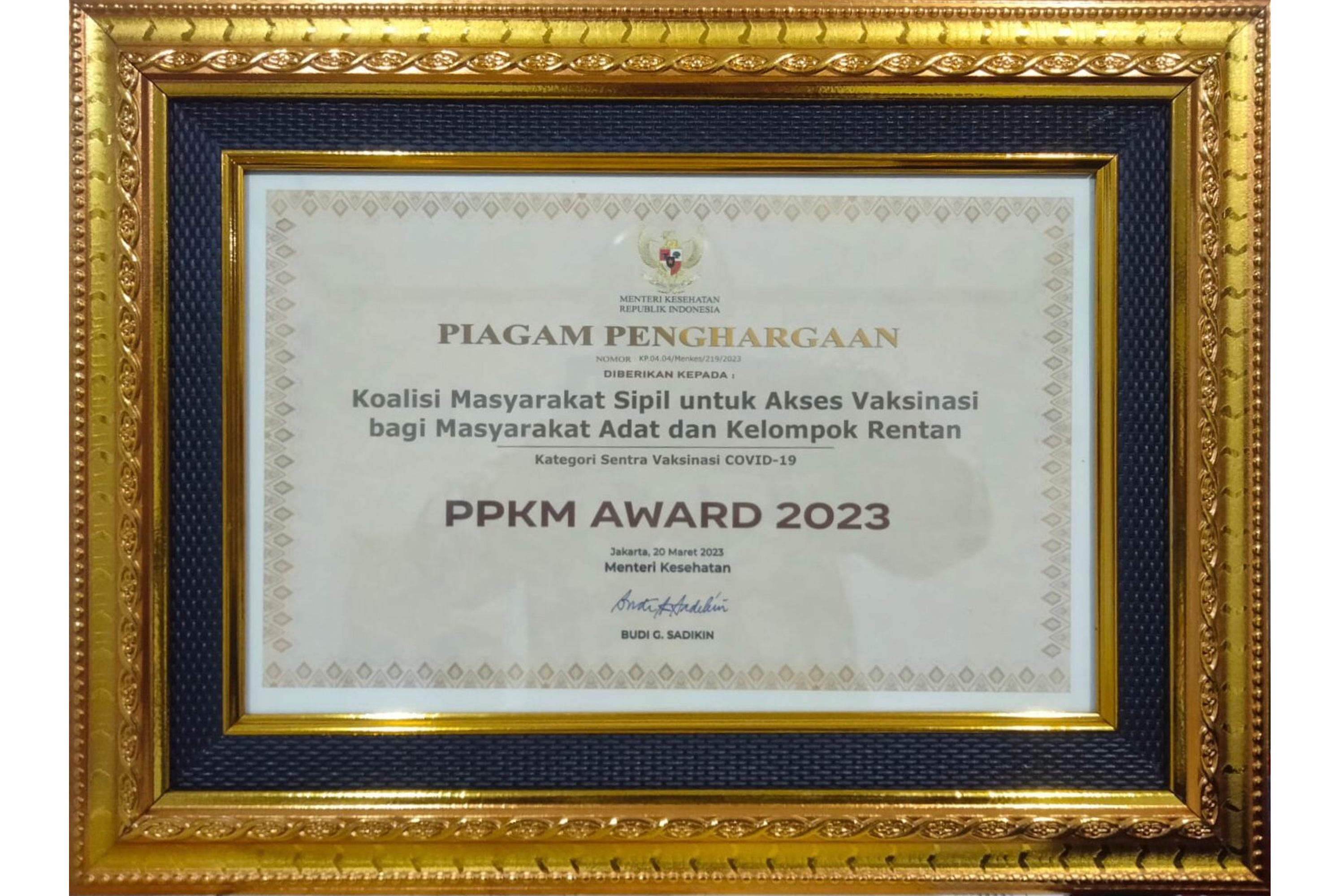 Piagam penghargaan kategori Sentra Vaksinasi COVID-19 kepada Koalisi Masyarakat Sipil untuk Akses Vaksinasi bagi Masyarakat Adat dan Kelompok Rentan